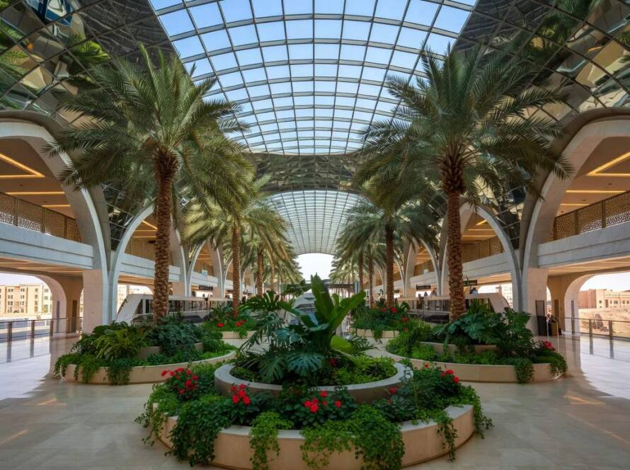 Estação de metrô em Riad com jardim subterrâneo e cobertura reflexiva, em estilo arquitetônico moderno.
