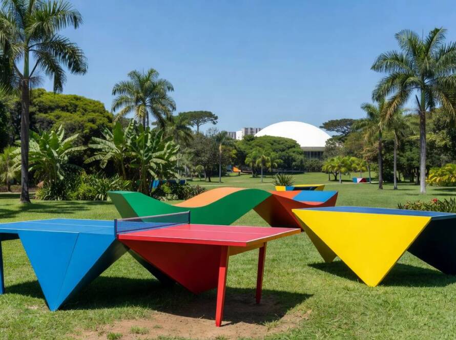 Mesas de ping pong geométricas como esculturas interativas em parque brasileiro, representando instalação artística inovadora.