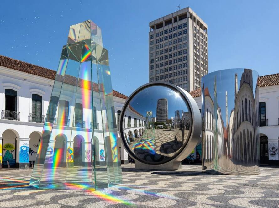 Instalação artística transformando cidade brasileira em playground fotográfico imersivo, com estruturas óticas e perspectivas distorcidas.